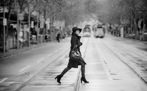 lady in trench coat crossing intersection on a cold winters day in melbourne