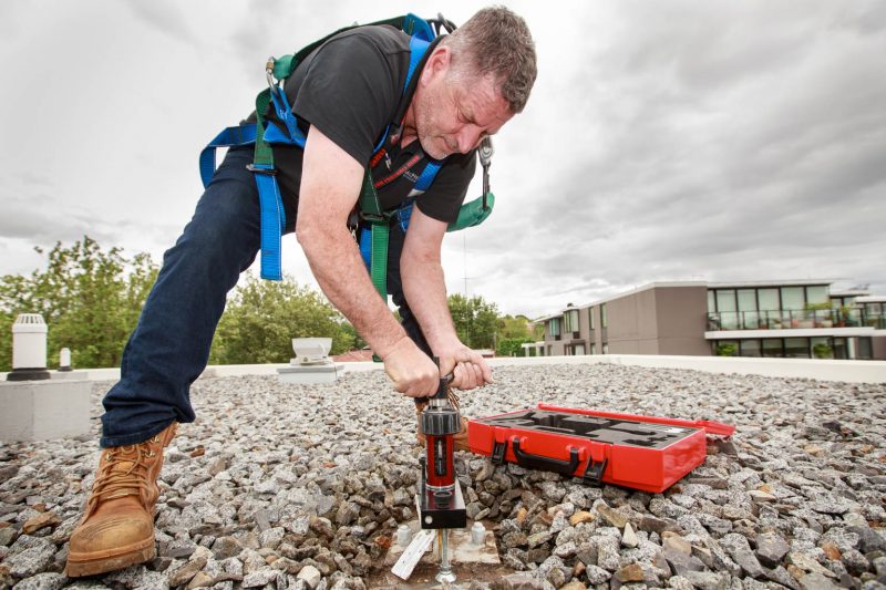 commercial photography of man on building roof pressure testing safety point